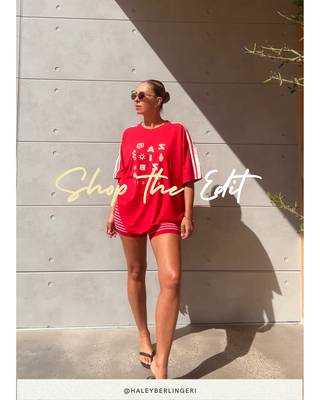 Woman in a red outfit standing against a gray wall with 'Shop The Edit' text overlay.