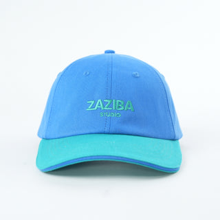Blue and green cap with 'Zaziba Studio' branding on a white background