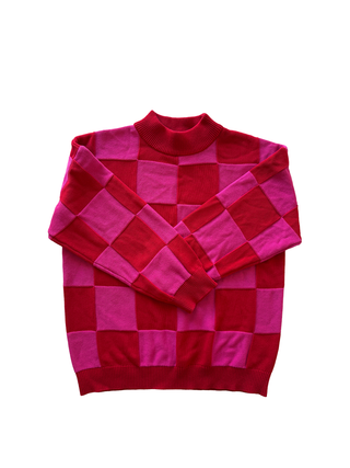 Red and pink checkered sweater on a white background