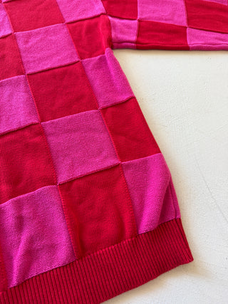 Pink and red patchwork blanket on a white surface
