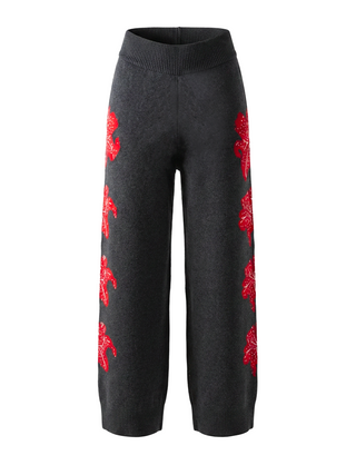 Black pants with red floral patterns on a white background