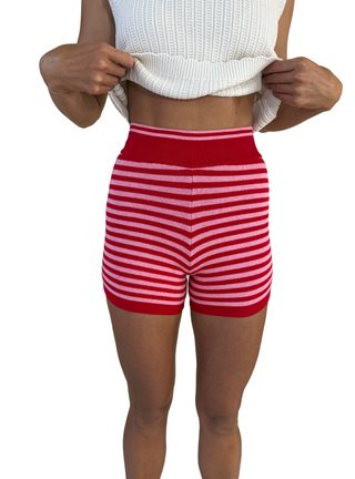 Red and white striped shorts worn by a person on a white background